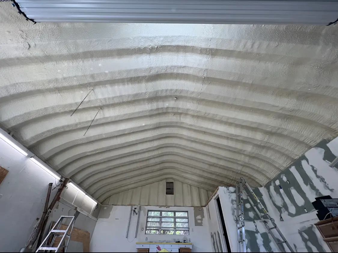 Spray polyurethane foam applied to the underside of a metal roof deck in Newton
